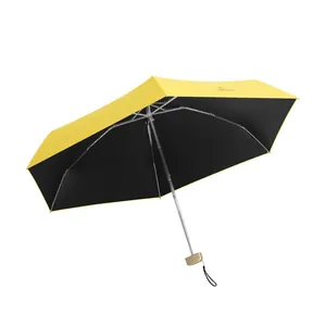 Compact yellow folding umbrella with UV protection and black inner coating