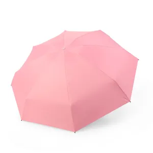 Compact pink folding umbrella for sun and rain protection, portable travel mini size.