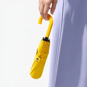 Elegant yellow foldable sun and rain umbrella with a stylish curved handle