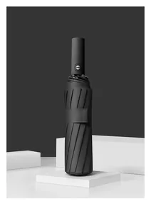Professional detail shot of a fully automatic black folding umbrella on white podiums