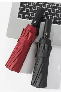 Close-up detail of red and black automatic folding umbrellas showing button and fabric texture