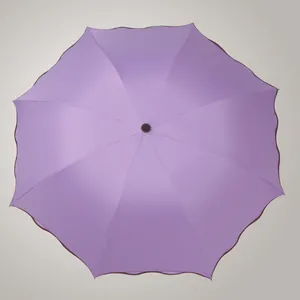 Vue de dessus d'un parapluie pliant violet avec des bords festonnés décoratifs élégants