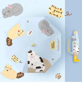Detailed view of light blue foldable umbrella with cute cat illustrations and pinwheel decor