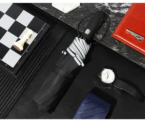 Paraguas automático negro cerrado con accesorios profesionales de estilo de vida de lujo.