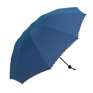 Large navy blue folding sun and rain umbrella with unique geometric patterned trim