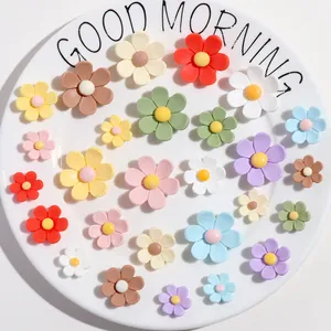 Close-up detail of multi-colored six-petal flower resin DIY charms on a white plate