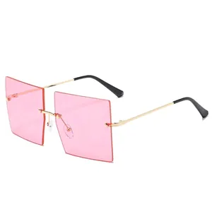 Lunettes de soleil carrées sans monture avec verres roses et branches dorées
