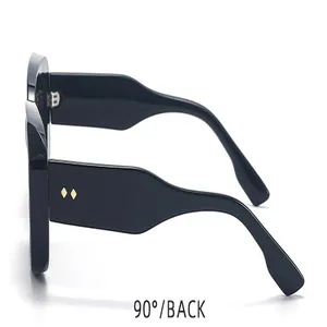 Vista detallada de gafas de sol cuadradas negras con protección UV y logotipo B