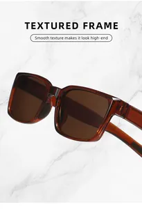 Nahaufnahme einer klassischen rechteckigen Sonnenbrille mit braunem, strukturiertem Rahmen.