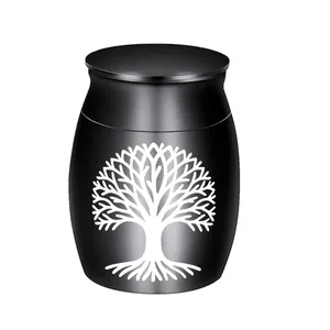 Detail of a small black memorial urn featuring a white Tree of Life engraving