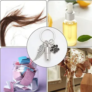Stainless steel cremation urn keychain with wing and paw charms for hair and oils