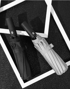 Detailed view of automatic folding umbrellas featuring black and silver fabric finishes.