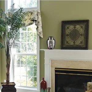 Decoratieve herdenkingsurn voor as met wit duifmotief in een rustige huiselijke setting
