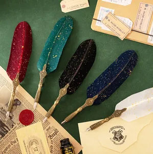 Detail view of five colorful vintage feather dip pens with ornate engraved metal handles