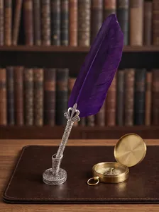 Vintage purple feather quill pen set with an ornate silver crown holder on a desk
