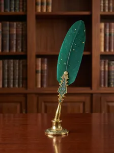 Detailed view of a vintage green feather dip pen with elegant gold filigree handle
