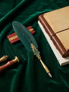 Detailed macro view of a vintage dark green feather dip pen with ornate gold handle