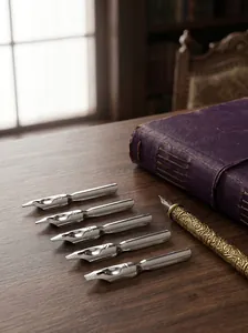 Detailed macro view of vintage metal fountain pen nibs and ornate brass holder