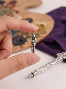 Close-up of vintage metal dip pen nib with engraved number and ornate handle