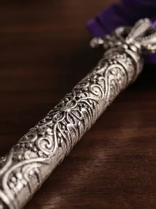 Macro detail of a vintage ornate silver crown quill pen barrel with intricate engravings