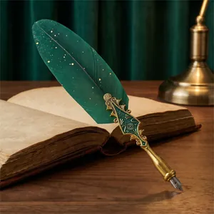 Exquisite dark green feather dip pen with ornate gold handle resting on a vintage book.