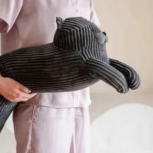 Gros plan d'un long coussin en peluche chat gris foncé avec texture côtelée douce.