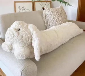 Oreiller de corps en peluche de lapin blanc doux placé sur un canapé confortable pour la chambre