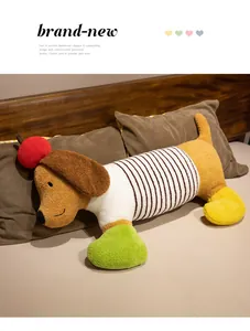 Long coussin en peluche teckel de dessin animé avec décoration de pomme sur un lit