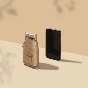 Tragbarer champagnergoldener UV-Schutz Mini-Regenschirm mit Smartphone-Größenvergleich