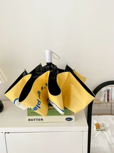 Detailed macro shot of a yellow automatic folding sun umbrella placed on decorative books.