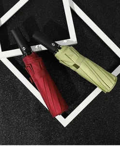 Automatic folding umbrellas in burgundy and green on a modern black background