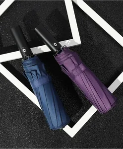 Detail view of navy and purple automatic folding umbrellas with sleek black handles