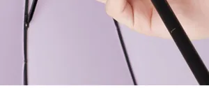 Macro view showing a hand holding the sturdy black shaft of a purple long-handle umbrella.