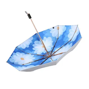 Foldable sun and rain umbrella with blue daisy floral print and rose gold frame