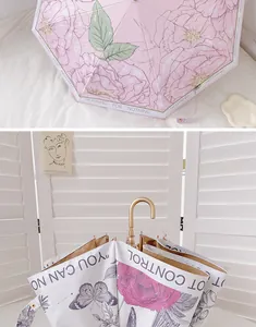 Détail d'un parapluie floral vintage avec motifs papillons et poignée en J dorée
