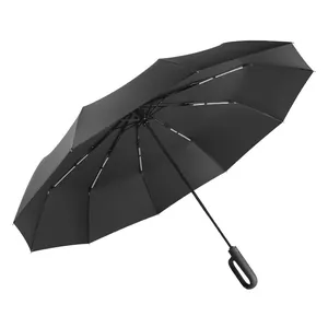 Large black automatic folding umbrella designed for sun and rain protection with ergonomic handle