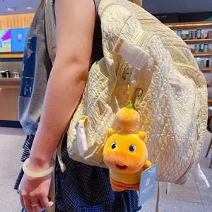Süßer Plüsch-Wasserschwein-Schlüsselanhänger mit Orangen-Deko an einem beigen Rucksack