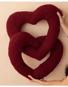 Detail van de in elkaar grijpende bordeauxrode teddy fluwelen hartkussens voor decoratie