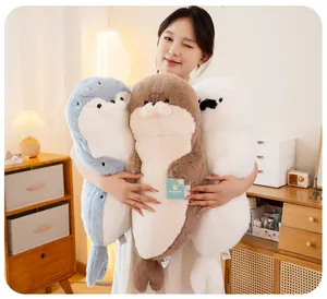Asian model holding three colorful soft sea otter plushies in a cozy bedroom setting