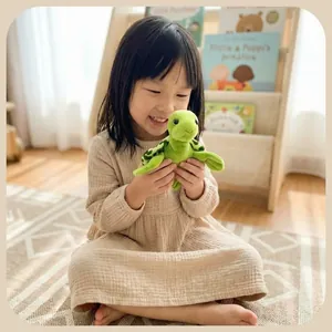 Une petite fille souriante tenant une peluche tortue de mer verte dans une chambre ensoleillée.