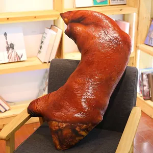 Realistic 3D roasted pig trotter plush pillow with detailed food print texture on a chair