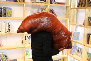 Large realistic cooked pig trotter plush pillow carried by a person in detail view