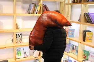 Detail showing a person holding the oversized realistic pig trotter plush pillow