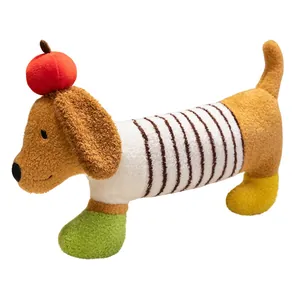 Coussin peluche teckel mignon avec chapeau pomme et chemise rayée pour un sommeil doux.