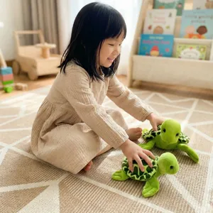 Jeune fille jouant avec deux adorables peluches de tortues vertes dans un intérieur