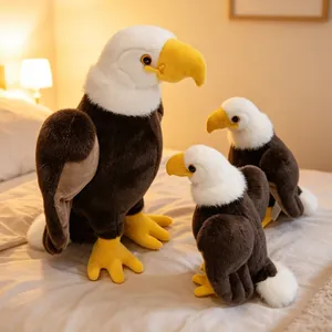 Set van drie realistische Amerikaanse zeearend knuffels in verschillende maten op een bed