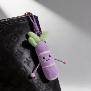 Vista detallada de un lindo llavero de peluche de caña de azúcar morada en un bolso negro