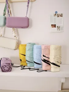 Gruppe bunter flacher Mini-Taschenschirme in Pastellfarben auf einem weißen Regal