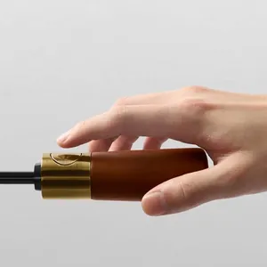 Luxury automatic folding umbrella handle detail with wood and gold metal finish