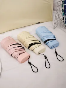 Detailansicht von drei kleinen Taschenschirmen in den Farben Rosa, Creme und Hellblau